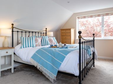 A bedroom with a metal bed frame and blue striped pillows and blanket at Flaad House in Rock