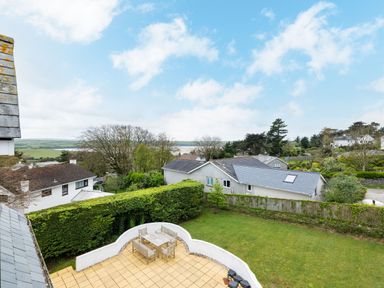 A garden with a patio area and outdoor furniture surrounded by hedges and houses at Flaad House in Rock