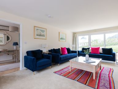 A living room with blue sofas and a colorful rug at Flaad House in Rock