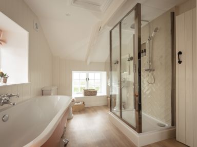 A bathroom with a bathtub toilet shower and window at Swallow Cottage in Port Isaac