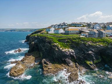 A coastal village with houses on cliffs overlooking the ocean at gulland port isaac