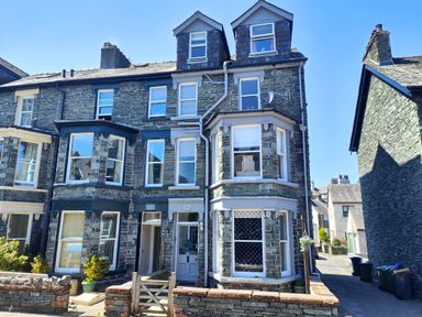 A stone terraced house with multiple windows and two dormer windows on the roof at Squirrel Lodge in Keswick
