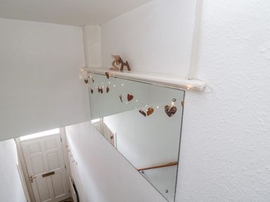 A hallway with a white front door and a mirror decorated with string lights and heart ornaments at Islestone 1 Temperance Terrace in Berwick-Upon-Tweed