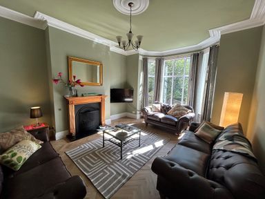 A living room with two sofas a fireplace a coffee table and large windows at South Bay House in Scarborough