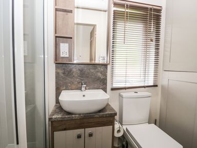 A bathroom with a sink cabinet mirror toilet and window blinds at Ashton Lodge - Sherwood 4 South Lakeland Leisure Village