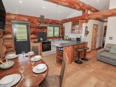 A kitchen with a dining area and seating at Cedar Cabin at Salford Court Farm Fishing Cabins Near Clifton Upon Teme