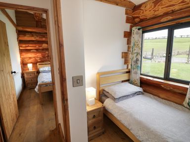 A bedroom with two beds and a window at Cedar Cabin at Salford Court Farm Fishing Cabins Near Clifton Upon Teme