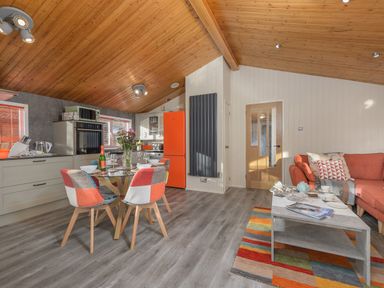 A kitchen and dining area with a wooden ceiling and orange accents at Oaks One Swarland near Felton