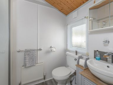 A bathroom with a toilet sink and towel rack at Oaks One Swarland near Felton