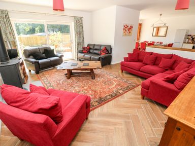 A living room with red and black sofas a wooden coffee table and patterned rug at 1 The Warren Robeston Wathen near Narberth