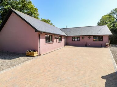 A single-story house with pink exterior walls and a paved driveway at 1 The Warren Robeston Wathen near Narberth