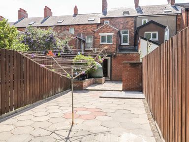 A paved backyard with a rotary clothesline and wooden fences at Number 91 in Belfast County Antrim