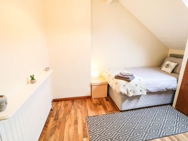 A small bedroom with a single bed a bedside table with a lamp wooden floor and a rug at Number 91 in Belfast County Antrim