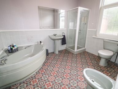 A bathroom with a corner bathtub sink shower toilet and bidet at Number 91 in Belfast County Antrim