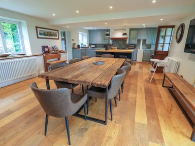 A kitchen and dining area with a wooden table and chairs at Flaska House in Troutbeck Near Penrith
