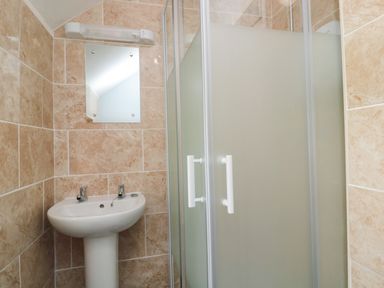 A bathroom with a pedestal sink mirror above and a shower cubicle with frosted glass doors at 1 Roddam Rigg Cottage Roddam near Wooler