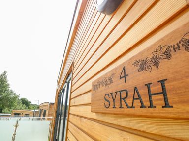 Exterior view of wooden buildings with balconies and a sign labeled syrah number 4 at Syrah in Seaview