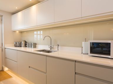 A kitchen counter with a sink toaster kettle canisters microwave and paper towel holder at 5 Keeper's Cottage Hillfield Dartmouth