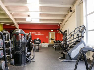 A gym with exercise machines weights and a motivational quote on the wall at Number 8 Lakes View in Brean