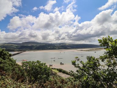 A coastal view with boats on water and hills in the background at Windycroft in Barmouth