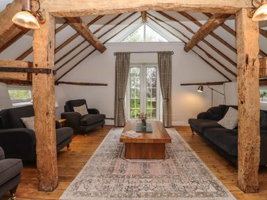 A sitting room with wooden beams two sofas a wooden coffee table and glass doors at 1 White House Cottages Bromsash near Lea