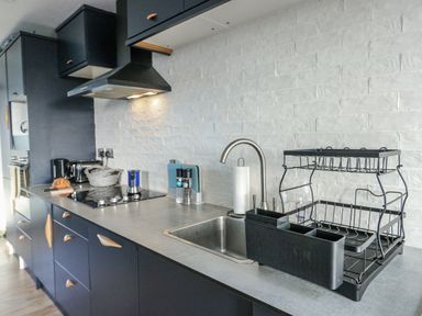 A kitchen with a sink and dish rack at 7 Bro Branwen Aberffraw near Rhosneigr
