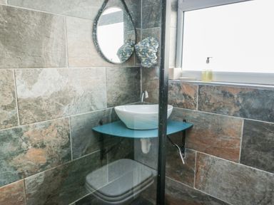 A bathroom featuring a sink and a shower at 7 Bro Branwen Aberffraw near Rhosneigr
