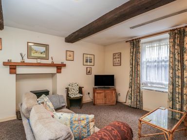 A living room with a sofa and television at Dollar Ward House Basement Cirencester