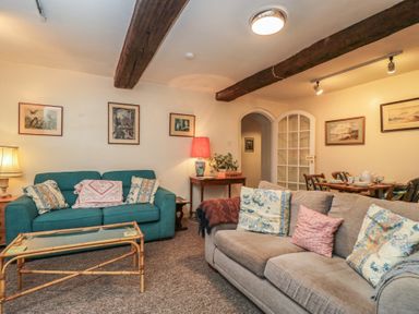 A living room with sofas and a table at Dollar Ward House Basement Cirencester