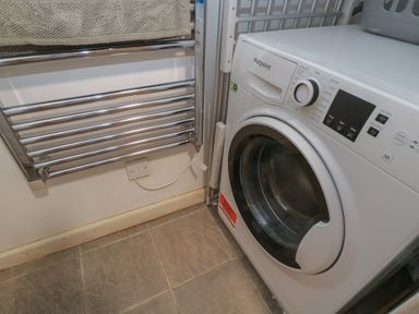 A laundry room with a washing machine and a towel rail at Dollar Ward House Basement Cirencester