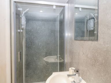 A bathroom with a shower enclosure sink and a mirror at The Apartment at Plas Yr Eithin in Amlwch near Llanfechell
