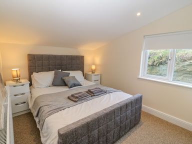 A bedroom with a bed and bedside tables with lamps at The Apartment at Plas Yr Eithin in Amlwch near Llanfechell