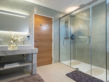 A bathroom with a double sink vanity and a glass-enclosed shower at Seascape in Polzeath
