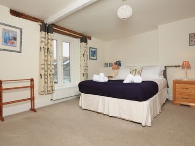 A bedroom with a bed and bedside tables by a window at Ferry View in Dartmouth