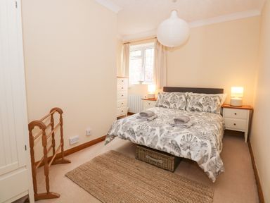 A bedroom with a bed and bedside tables with lamps at 16 Norfolk Heights in Docking