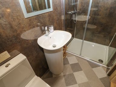 A bathroom with a toilet sink and shower with glass doors at Foxes Den in Winston near Staindrop