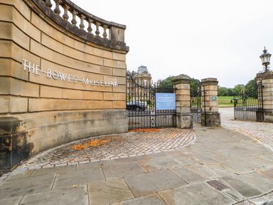The entrance gate with stone wall and metal railings at The Bowes Museum