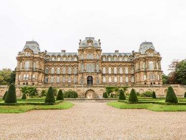 A large symmetrical stone building with multiple windows and a formal garden with conical bushes in front at Otters Holt in Winston near Staindrop