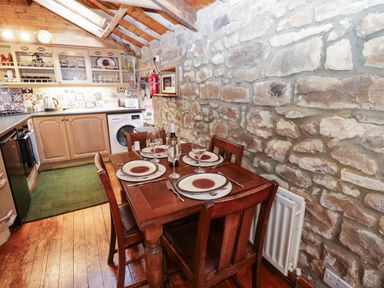 A kitchen with a dining table set at The Granary in Rothbury