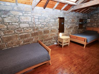 A bedroom with two beds and a bedside table at The Granary in Rothbury