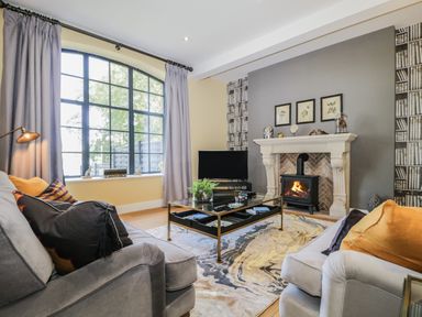 A living room with sofas a coffee table a fireplace and a large window at Tarn End Cottages 5 Talkin near Brampton Cumbria