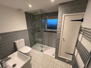 A bathroom with a toilet sink shower and towel rack at Beech Cottage in Combe Martin