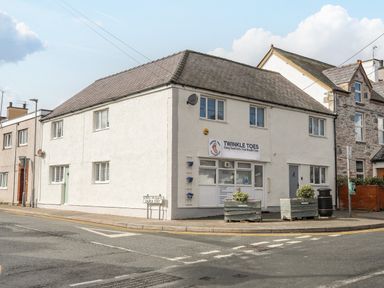 A corner building with a clinic sign and planters outside on a street named Church Street at Y Goedwig in Newborough