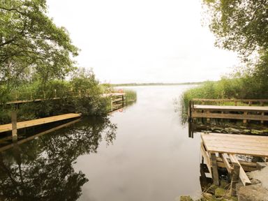 A lake with wooden docks and trees on the sides at Port Heron Lodge Ballykeeran near Glasson County Westmeath