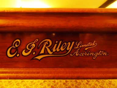 A close-up of an E P Riley Limited Accrington logo on a wooden surface