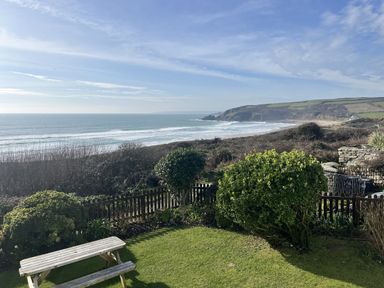 An outdoor view of the ocean and hillside at Stonecroft in Praa Sands