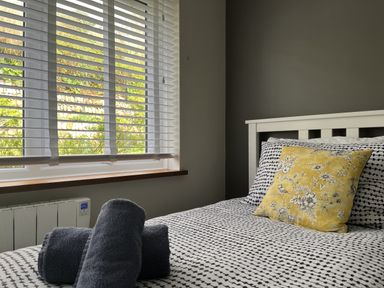 A bedroom with a bed and decorative pillow at Stonecroft in Praa Sands
