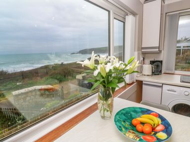 A kitchen with a fruit bowl and flowers at Stonecroft in Praa Sands
