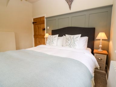 A bedroom with a double bed with pillows and lamps on bedside tables at 4 Lower Folley in Chipping Campden