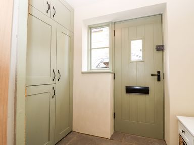 An entryway with a green front door and matching green cabinets at 4 Lower Folley in Chipping Campden